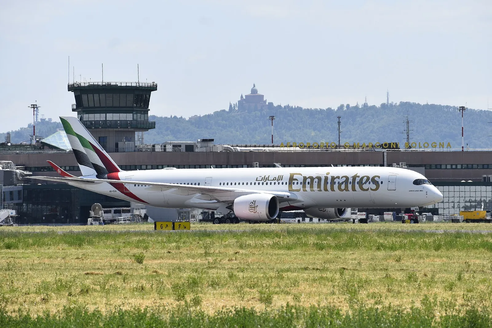 Airbus A350 на Emirates в Болоня; метаданните са с дата 12 февруари 2026 г. Архивен контекст за превозвача; не показва изложението или демонстрация на услугите.