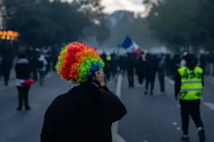 Демонстранти в Париж по време на протеста на 17 октомври 2026 г.; участник носи многоцветна перука.