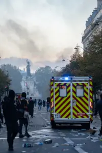 A fire brigade ambulance in a smoke-filled Paris street during the 17 October protests.