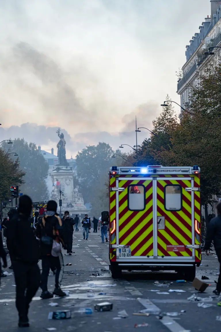 A fire brigade ambulance in a smoke-filled Paris street during the 17 October protests.