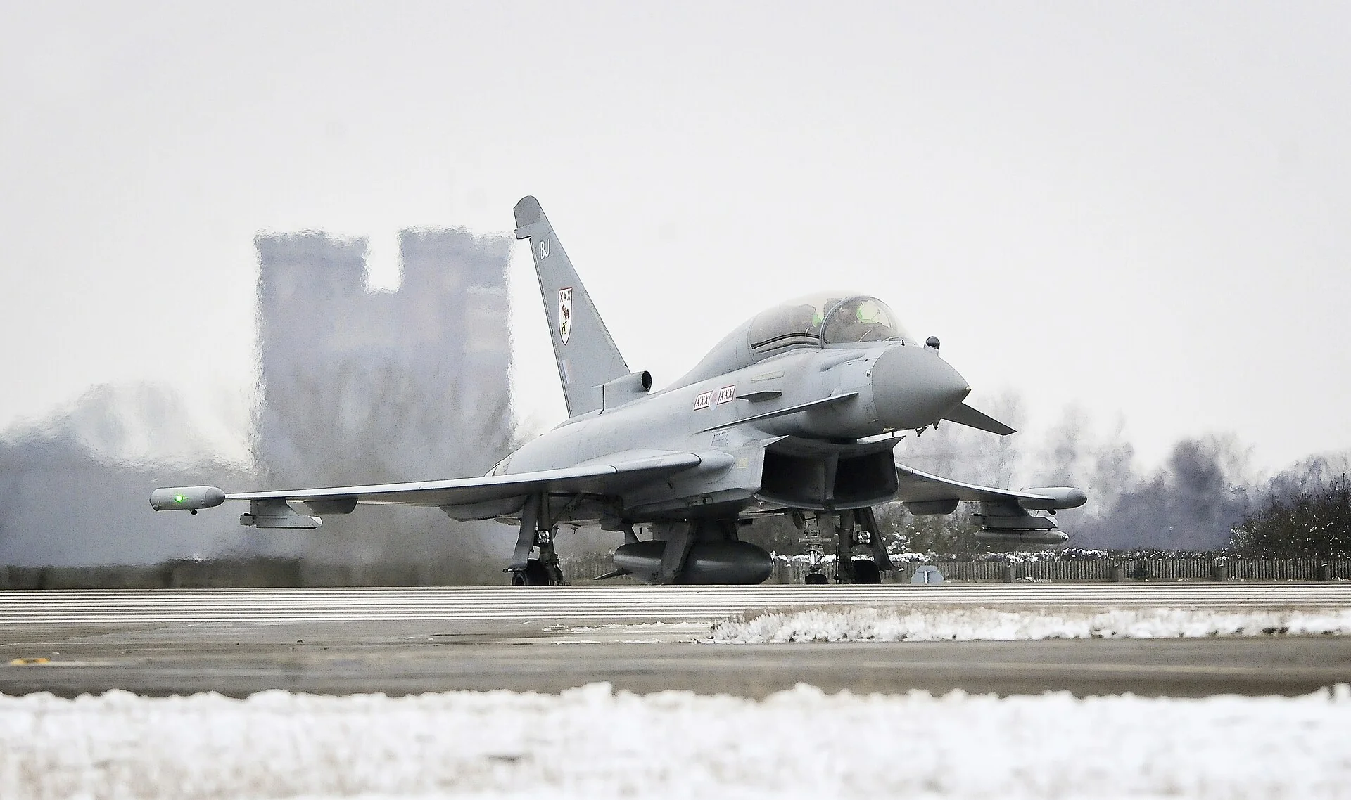 RAF Typhoon aircraft on a snow-lined runway at Coningsby.